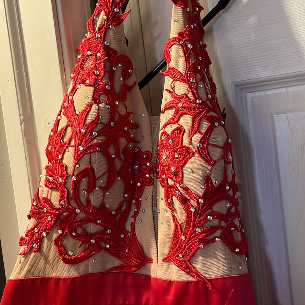 Macy’s red halter ball gown prom dress. The brand of this dress is by TLC.